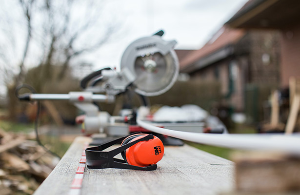 image of ear muffs sitting on bench with a silent air compressor